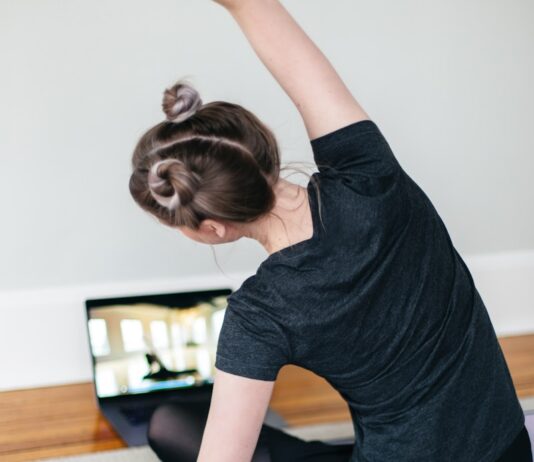 집에서 쉽게 할 수 있는 홈트레이닝 프로그램 woman in black t-shirt and black pants lying on black yoga mat