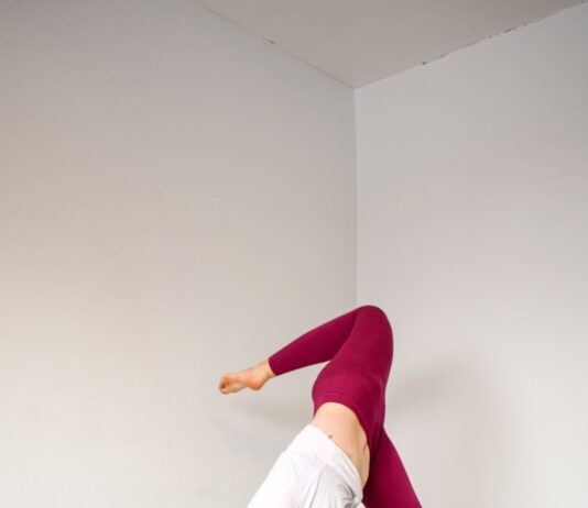 요가와 필라테스를 통한 스트레스와 면역력 관리 woman in white tank top and purple leggings doing yoga